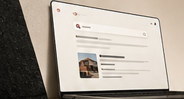 Laptop on a stone surface showing a search page with a building photo in the results